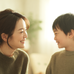 新札幌で小児矯正を検討する親子が笑顔で見つめ合う、清潔感と安心感のある温かい雰囲気のイメージ画像