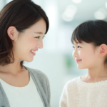 新札幌・北広島で小児矯正を検討する親子が笑顔で話す様子。明るく清潔感のある歯科医院のイメージ。