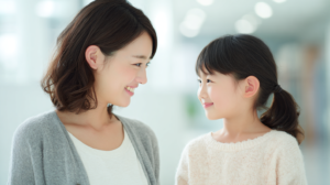 新札幌・北広島で小児矯正を検討する親子が笑顔で話す様子。明るく清潔感のある歯科医院のイメージ。