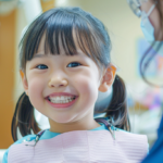 明るい歯科医院で笑顔を見せる親子。北広島・札幌での小児矯正の相談時期と安心感を表現したイメージ。