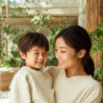 新札幌の明るい歯科医院で、小児矯正の相談を前に笑顔で過ごす親子。安心感のある温かい雰囲気。