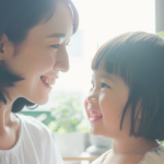 札幌市厚別区で小児矯正を検討する親子が、明るい歯科医院で安心して笑顔で話している様子。