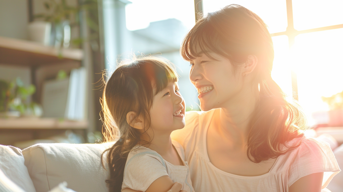 札幌市での小児矯正相談を前に、明るい光の中で笑顔で向き合う親子。安心感と信頼を表現したイメージ。