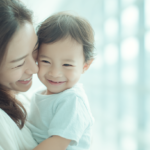 新札幌の明るい歯科医院で、小児矯正の相談を前に安心して笑顔で見つめ合う親子と温かい自然光の風景