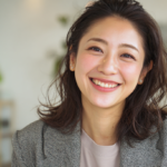 明るい自然光が入る部屋で、笑顔で自信を持って会話を楽しむ大人のマウスピース矯正を検討する世代の女性