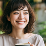 Smiling woman holding a cup of coffee in a cozy, plant-filled café.