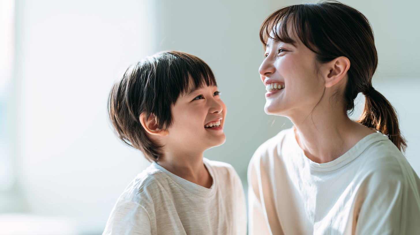 自然光が差し込む部屋で、安心した表情で笑顔で見つめ合う親子