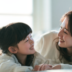 自然光の差し込む部屋で、笑顔で向かい合う親子の様子