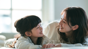 自然光の差し込む部屋で、笑顔で向かい合う親子の様子
