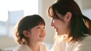 自然光が入る明るい部屋で穏やかに微笑み合う親子の姿と小児矯正の相談イメージ