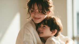 自然光が差し込む明るい室内で、鏡を見つめながら笑顔で寄り添う親子と子どものお口の健やかな成長
